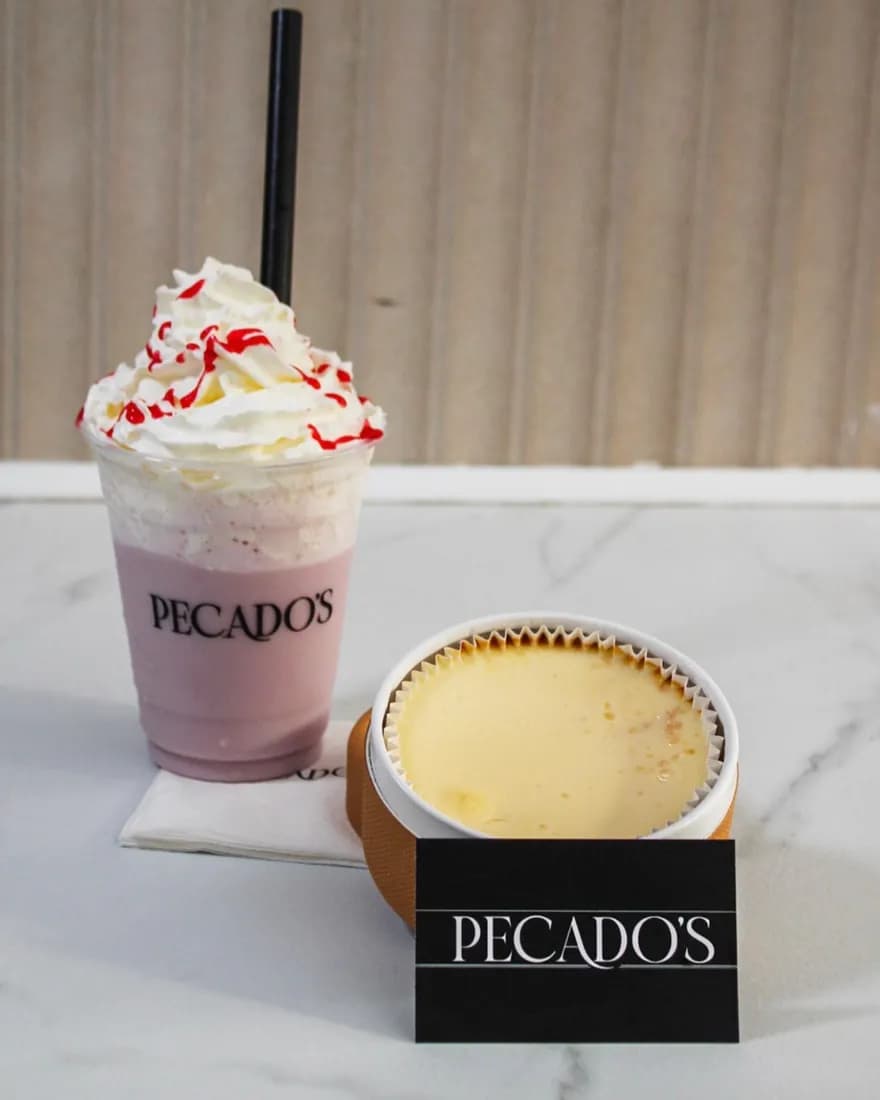 Milkshake de fresa y tarta de queso tradicional de Pecados sobre una mesa de mármol